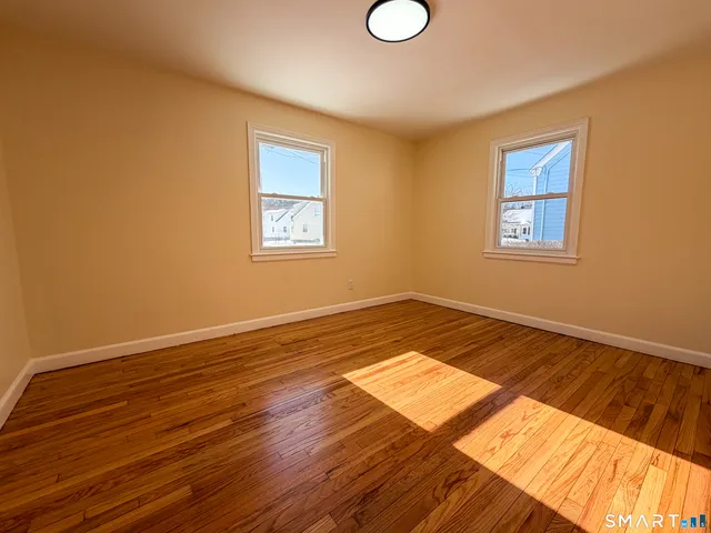 a view of a room with wooden floor and white walls