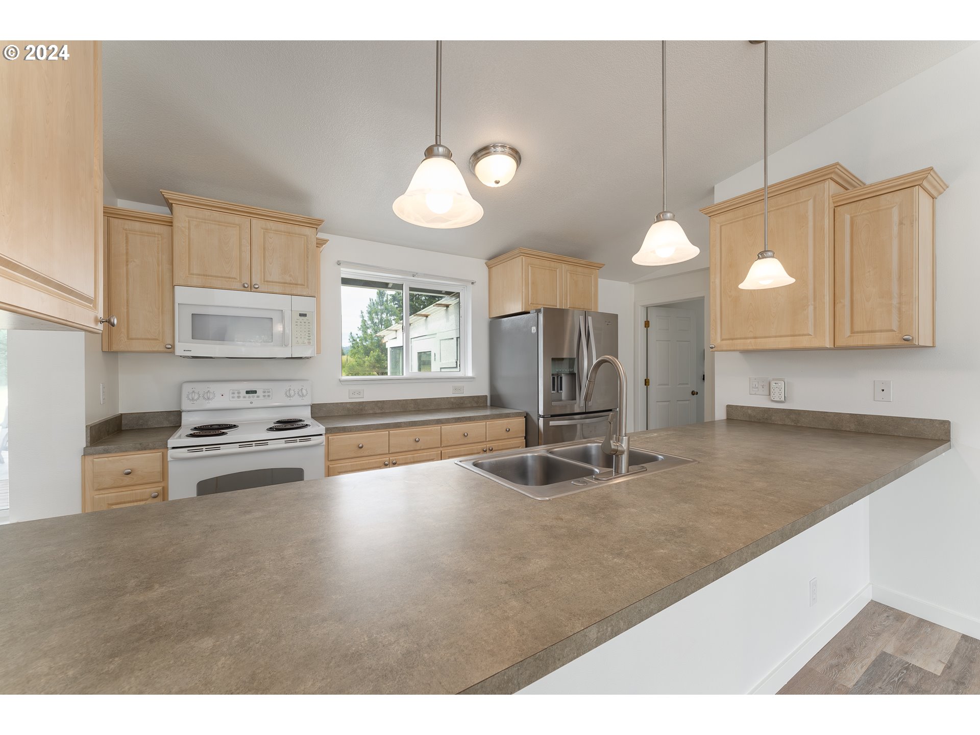 510 Reston Road Tenmile, OR 97481 - Photo 7 of 36 a kitchen with stainless steel appliances granite countertop a sink a stove and a wooden floors