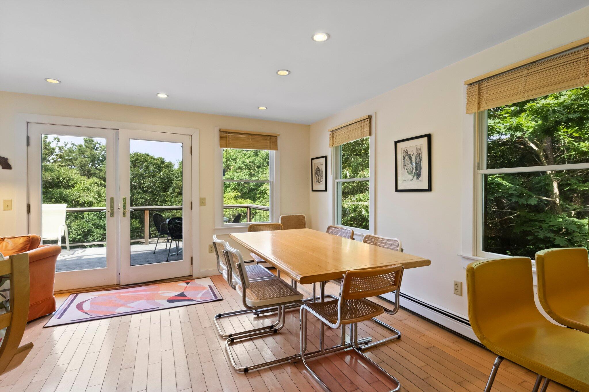 112 Castle Road Truro, MA 02666 - Photo 12 of 43 a view of a dining room with furniture large windows and wooden floor
