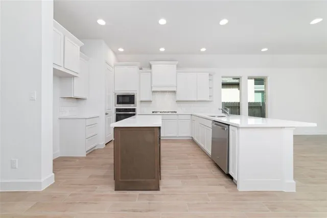 a kitchen with kitchen island sink stove and refrigerator
