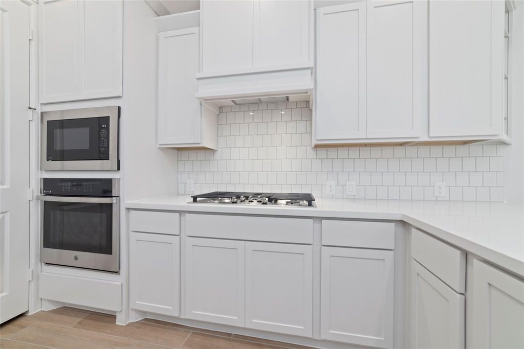 1434 Girasol Street Magnolia, TX 77354 - Photo 14 of 22 a kitchen with white cabinets and white appliances