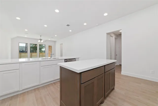 a kitchen with a sink and wooden floor