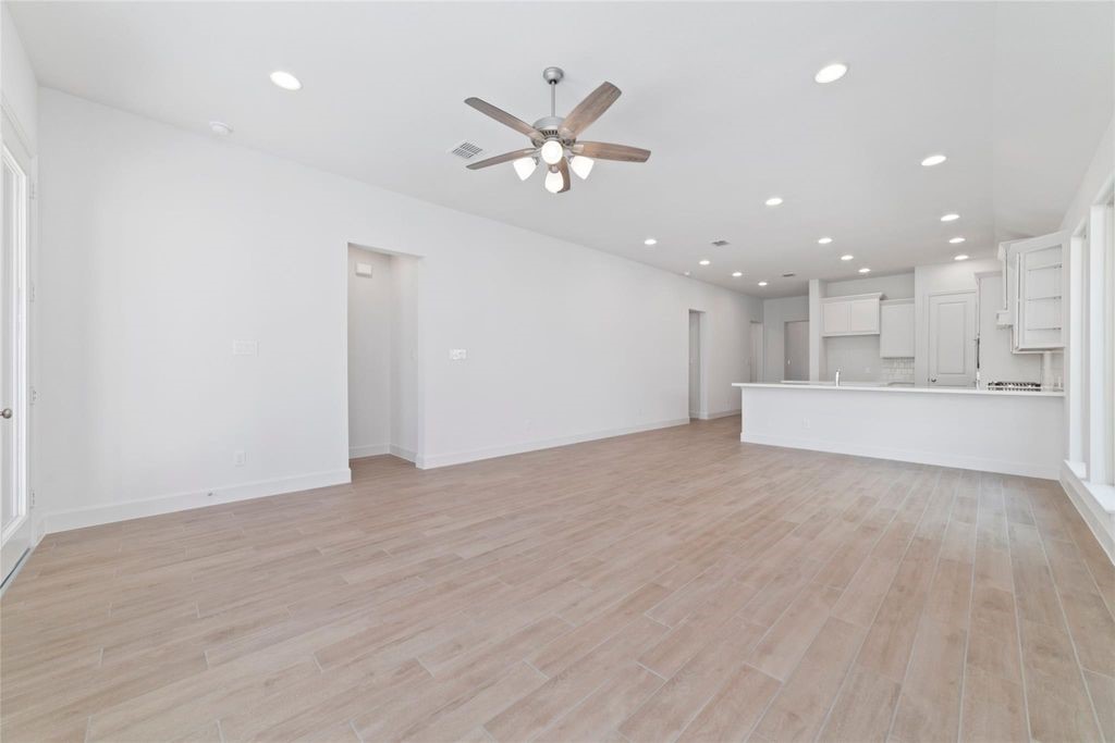 1434 Girasol Street Magnolia, TX 77354 - Photo 17 of 22 a view of an empty room with a ceiling fan and kitchen view