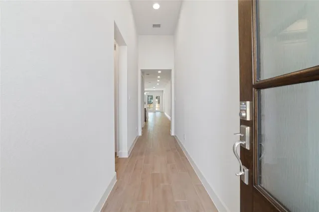 a view of a hallway with wooden floor and staircase