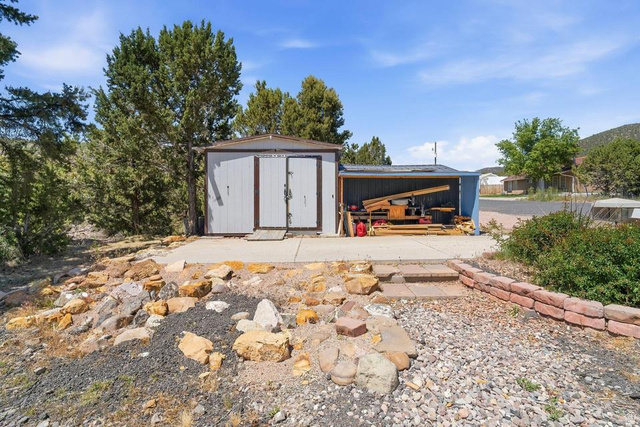 327 North Lodge Road Central, UT 84722 - Photo 36 of 45 Detached shed structure with a lean-to extension, set on a concrete slab