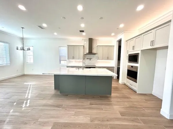 a view of kitchen with kitchen island a sink stainless steel appliances and cabinets