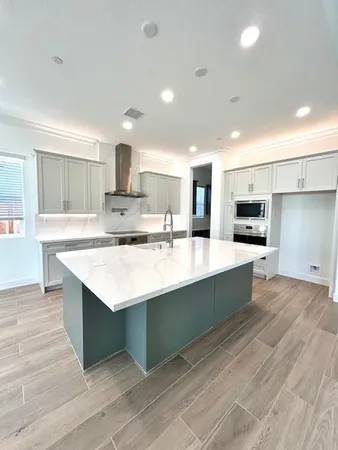 a large kitchen with kitchen island a sink stainless steel appliances and cabinets