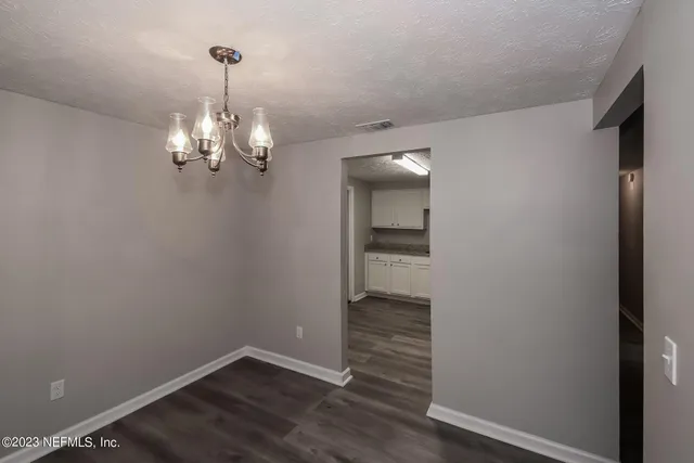 a view of a room with wooden floor and chandelier