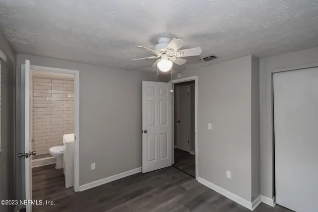 a view of a room with a stylish ceiling fan and hardwood floor