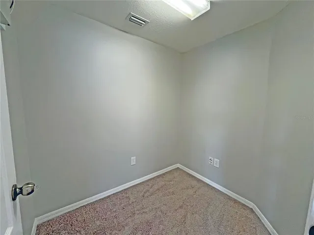 an empty room with windows and cabinet