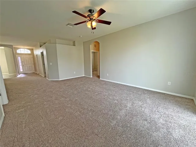 an empty room with a window and a fan