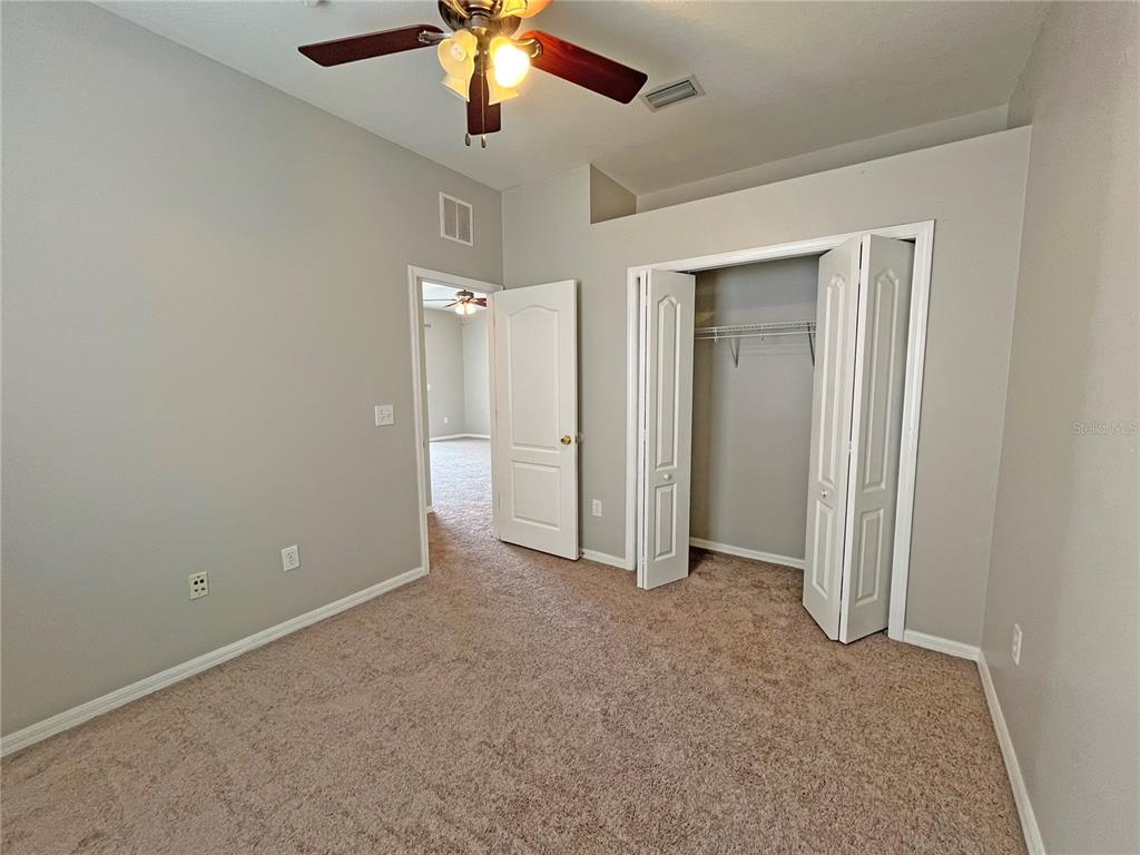24925 Vintage Court Lutz, FL 33559 - Photo 20 of 38 an empty room with closet and a chandelier fan