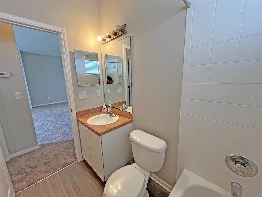 24925 Vintage Court Lutz, FL 33559 - Photo 22 of 38 a bathroom with a granite countertop toilet a mirror and shower