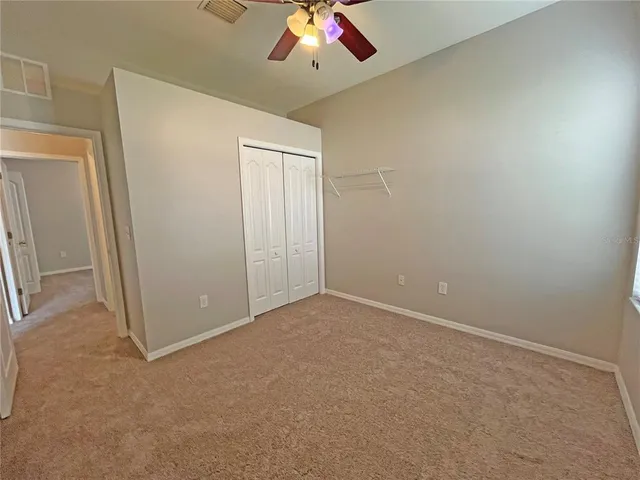 an empty room with chandelier fan