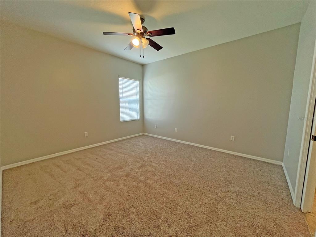 24925 Vintage Court Lutz, FL 33559 - Photo 27 of 38 an empty room with a chandelier fan and windows