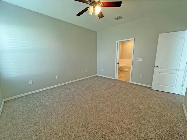 an empty room with closet and a chandelier fan
