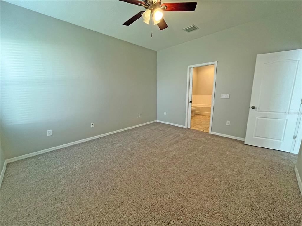 24925 Vintage Court Lutz, FL 33559 - Photo 28 of 38 an empty room with a ceiling fan and carpet