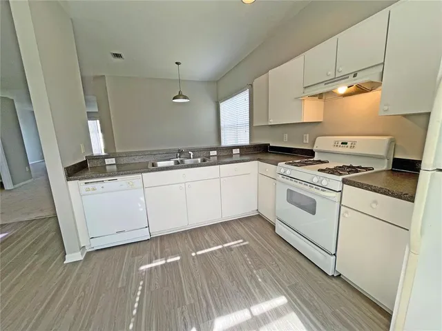 a kitchen with granite countertop a sink and a stove top oven