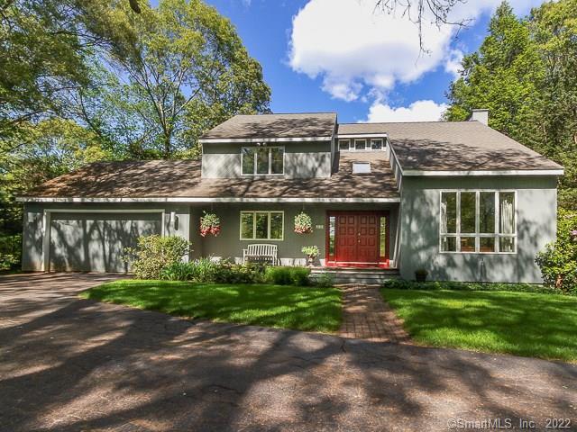 a front view of a house with a yard and trees
