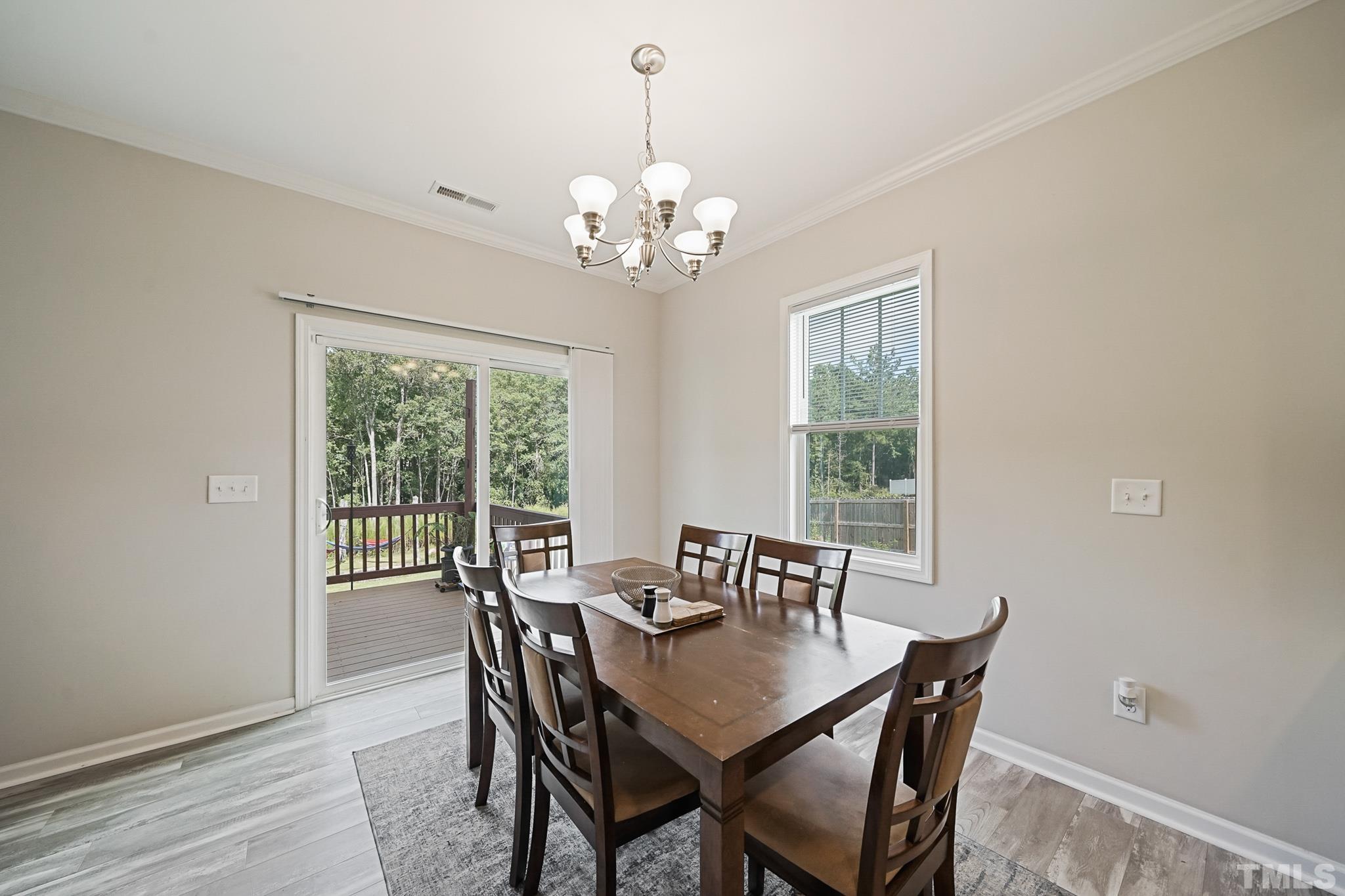 856 Juno Drive Broadway, NC 27505 - Photo 17 of 46 a view of a dining room with furniture a chandelier and wooden floor