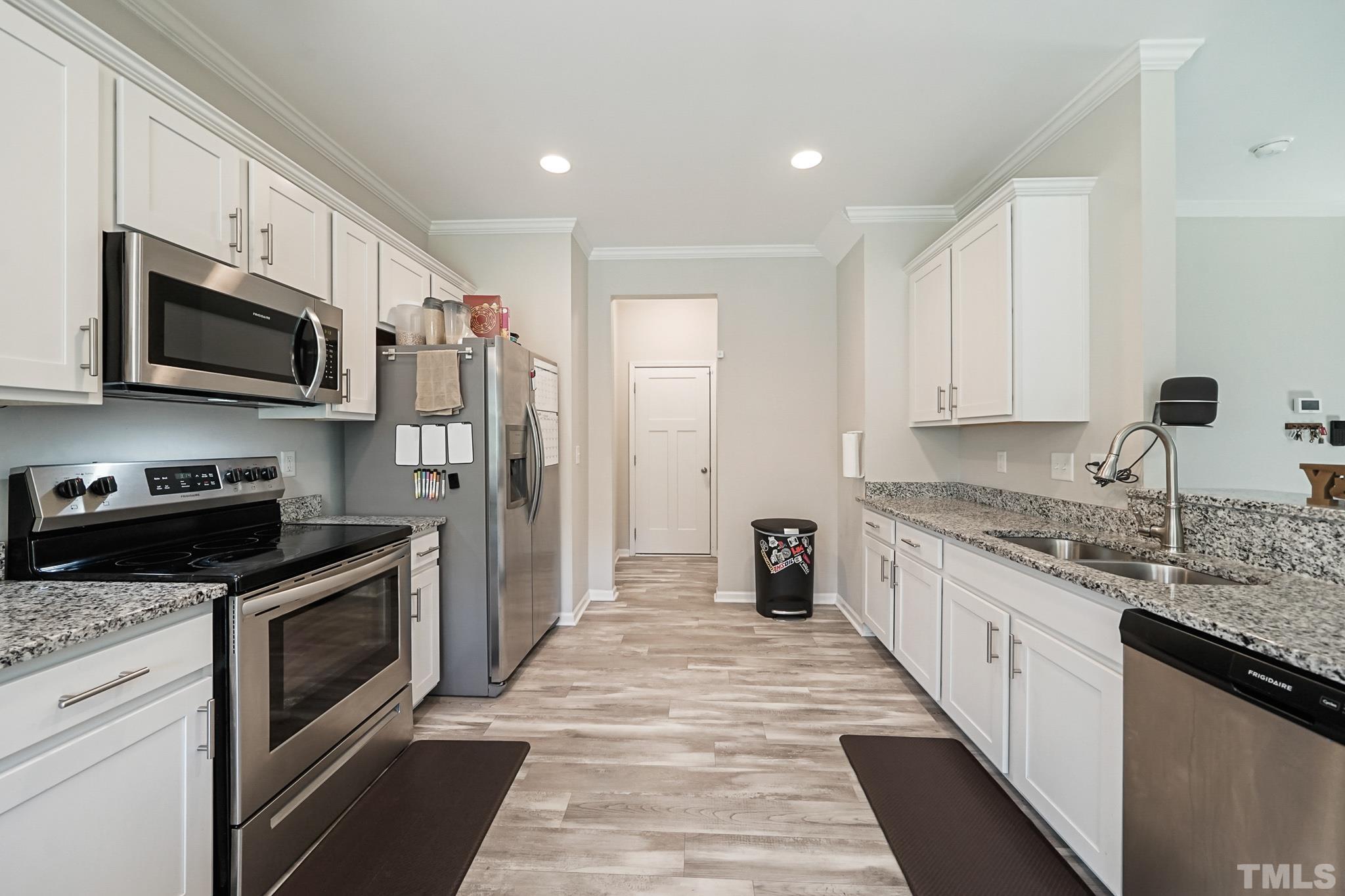 856 Juno Drive Broadway, NC 27505 - Photo 19 of 46 a kitchen with stainless steel appliances granite countertop a stove top oven a sink dishwasher a refrigerator and a microwave oven with wooden floor