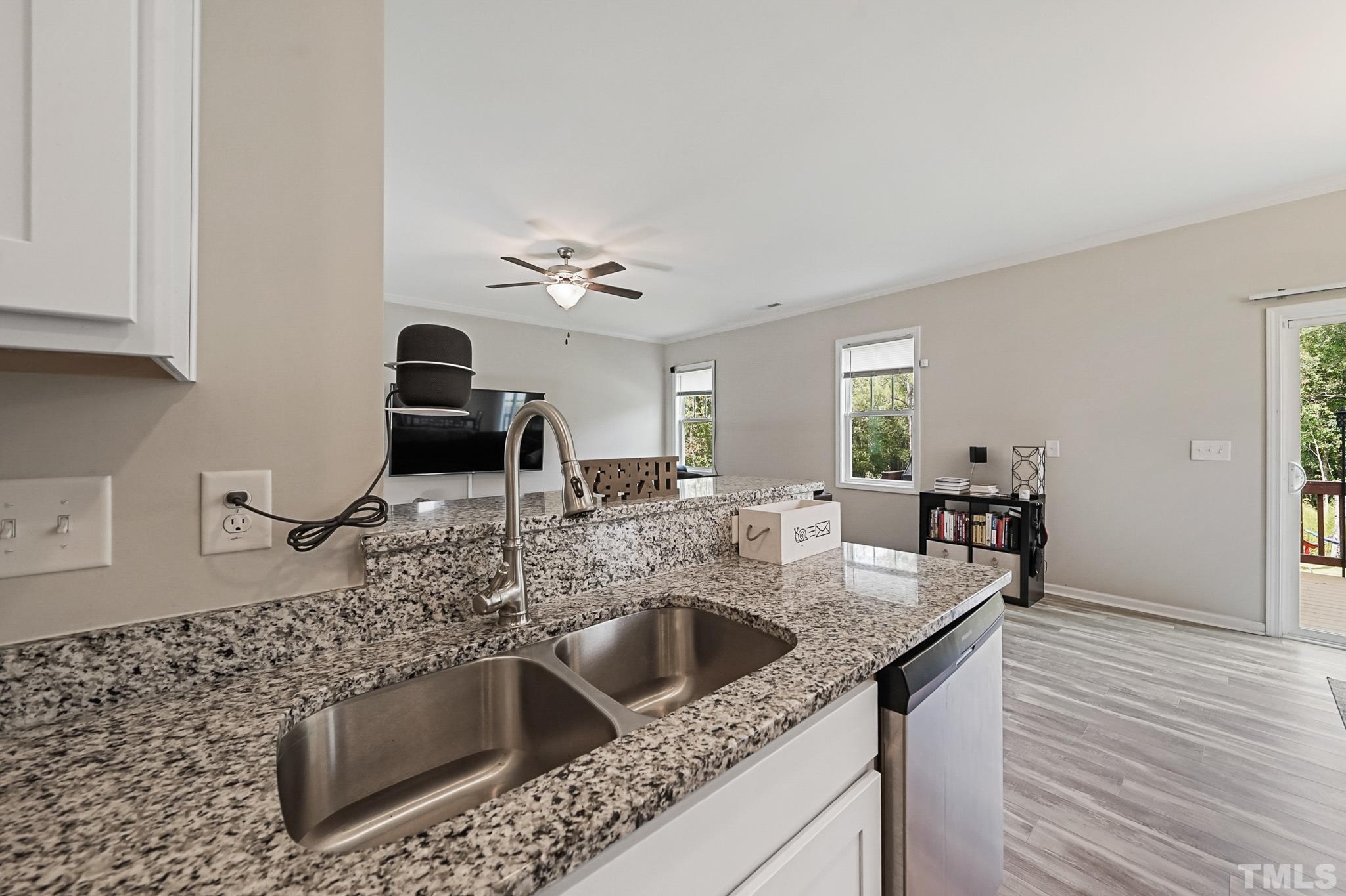856 Juno Drive Broadway, NC 27505 - Photo 20 of 46 a kitchen with granite countertop a sink and a stove top oven with wooden floor