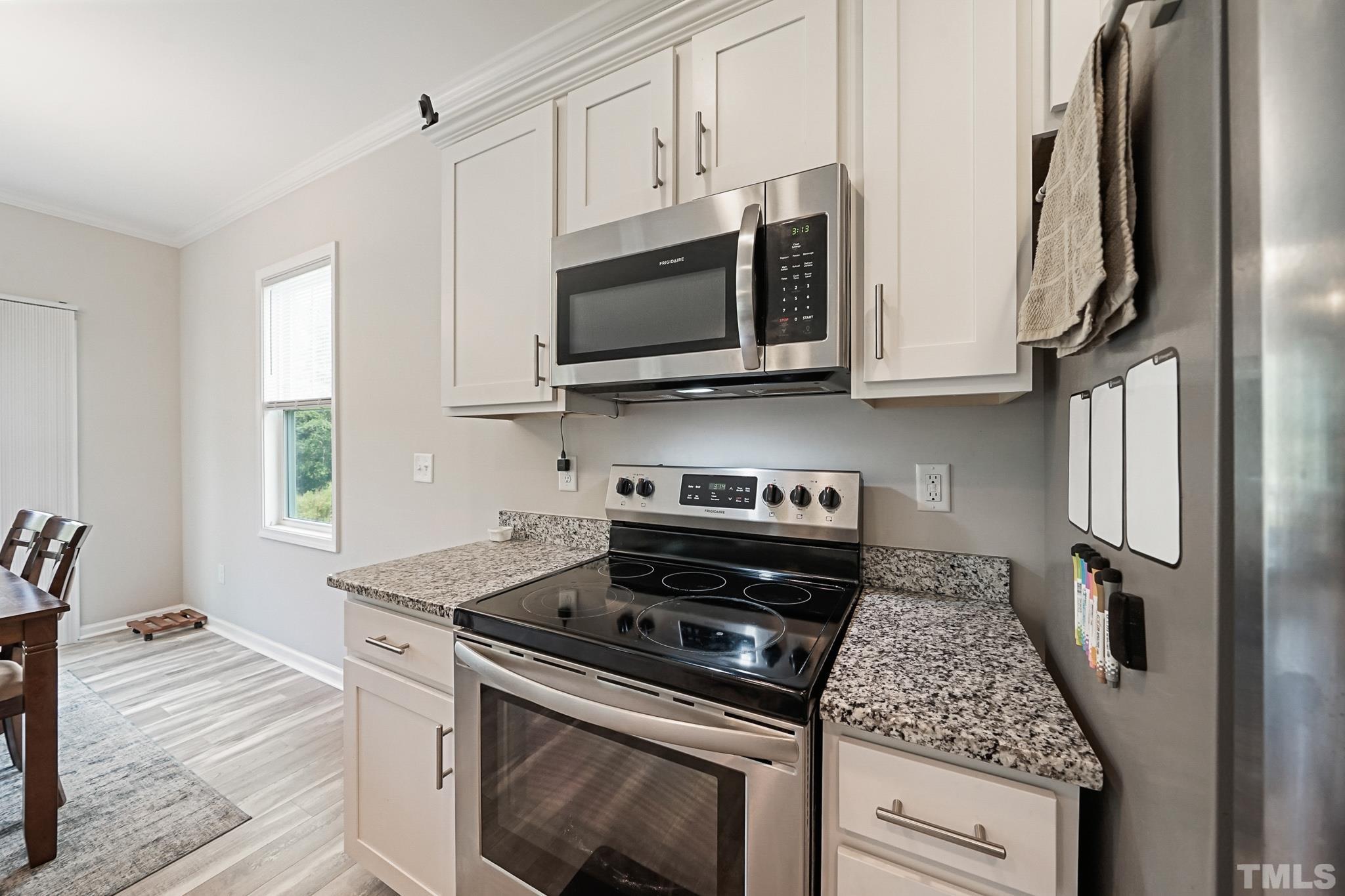 856 Juno Drive Broadway, NC 27505 - Photo 21 of 46 a kitchen with stainless steel appliances granite countertop a stove and a microwave