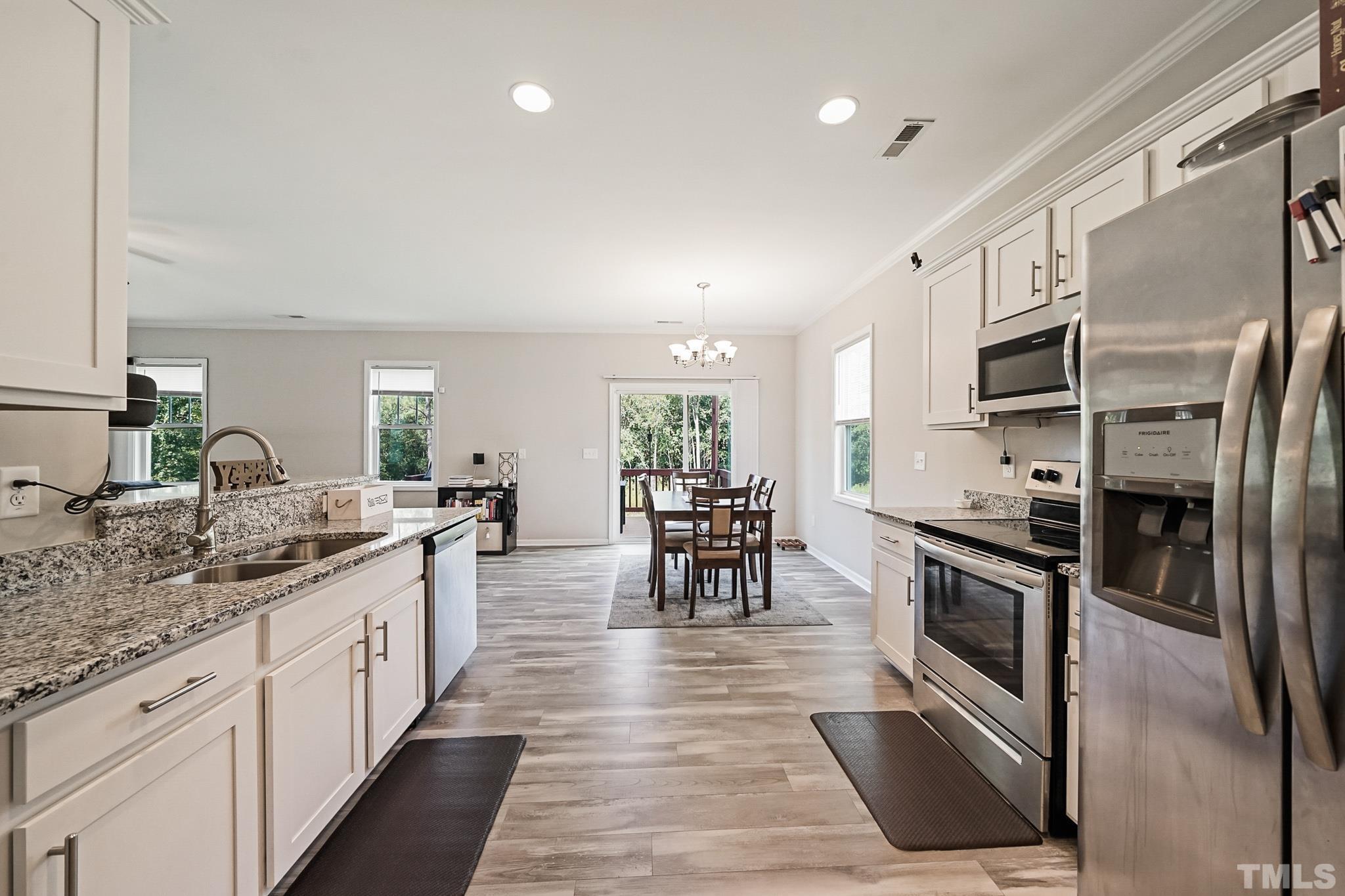 856 Juno Drive Broadway, NC 27505 - Photo 22 of 46 a kitchen with stainless steel appliances granite countertop a stove top oven a sink a dining table and chairs