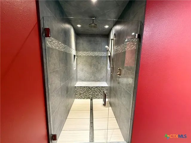 a bedroom with a large bed and a chandelier