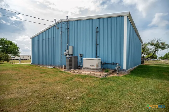 a view of a backyard with potted plants and large tree