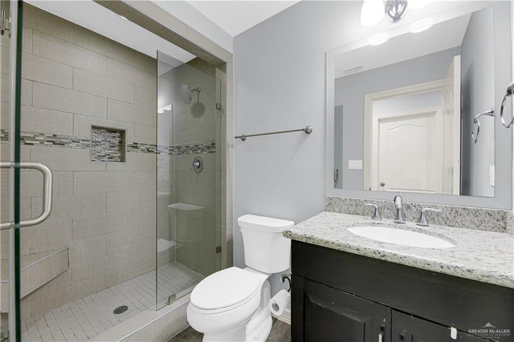 5305 North Crown Point Pharr, TX 78577 - Photo 20 of 24 a bathroom with a granite countertop sink toilet and shower