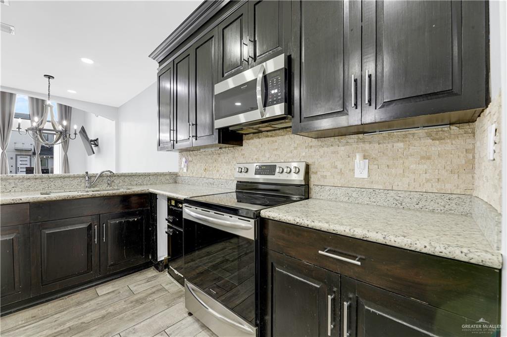 5305 North Crown Point Pharr, TX 78577 - Photo 9 of 24 a kitchen with stainless steel appliances granite countertop a sink stove and cabinets