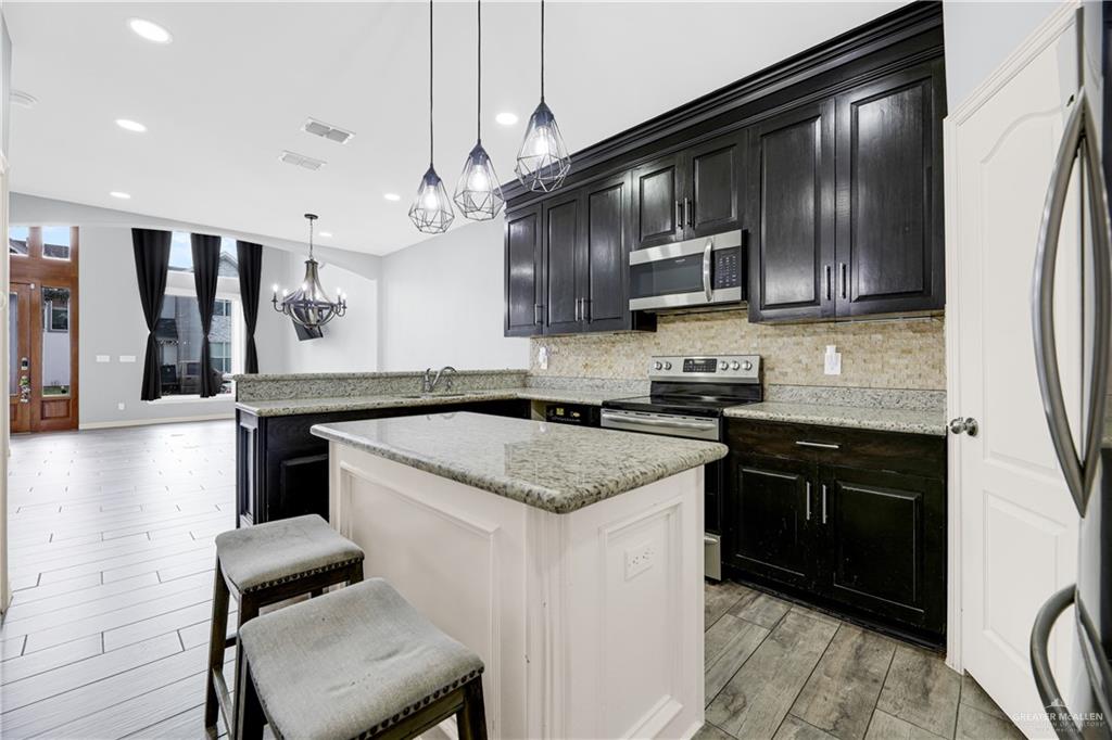 5305 North Crown Point Pharr, TX 78577 - Photo 10 of 24 a kitchen with stainless steel appliances granite countertop a sink stove and refrigerator