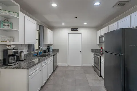 a kitchen with stainless steel appliances granite countertop a refrigerator and a stove