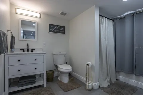 a bathroom with a toilet sink a mirror and shower