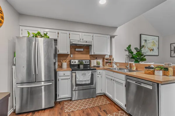 a kitchen with stainless steel appliances a refrigerator sink and microwave