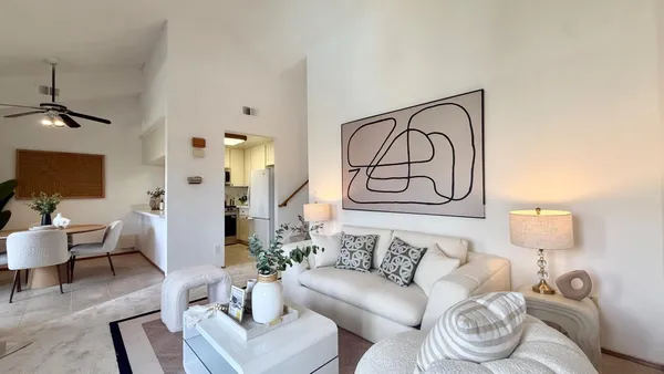 a living room with furniture and a painting on the wall