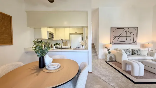a living room with furniture flowerpot and wooden floor