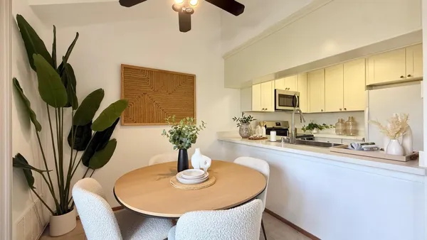 a kitchen with stainless steel appliances a dining table chairs and a refrigerator