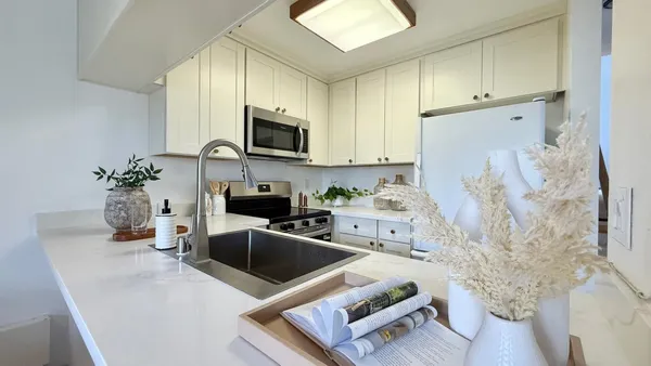 a kitchen with stainless steel appliances a stove a sink a microwave a refrigerator a cabinets and wooden floor