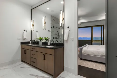 a bathroom with a granite countertop sink a mirror and a shower