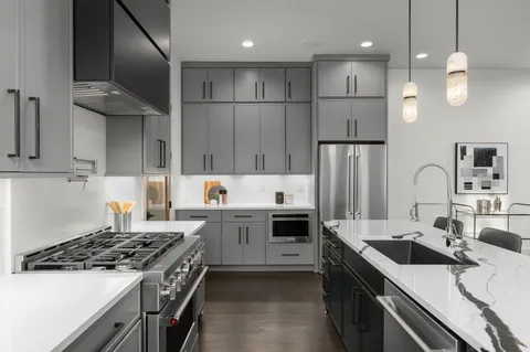 a kitchen with kitchen island a sink stainless steel appliances and cabinets