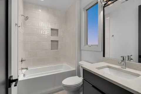 a bathroom with a sink toilet vanity and shower