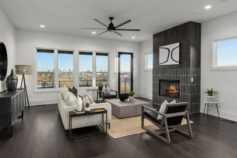 a living room with furniture fireplace and a large window