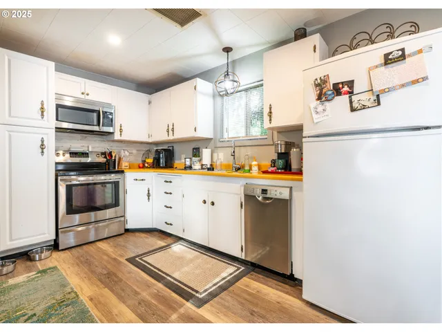 a kitchen with stainless steel appliances a refrigerator sink and cabinets