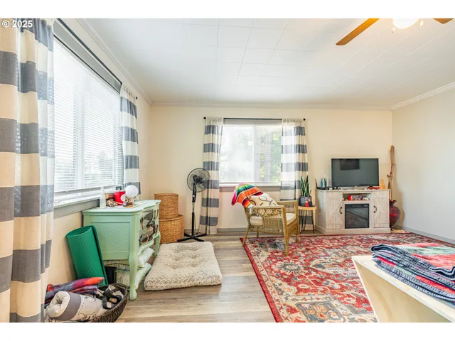 a living room with furniture a flat screen tv and a large window