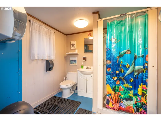 a bathroom with a toilet a sink and a shower curtain
