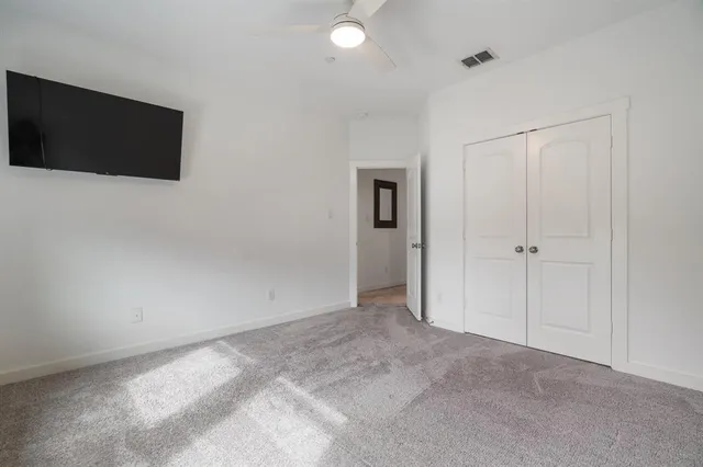 a view of an empty room with a tv and a wall painting