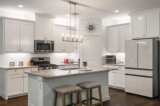 a kitchen with cabinets appliances a sink and a counter top space