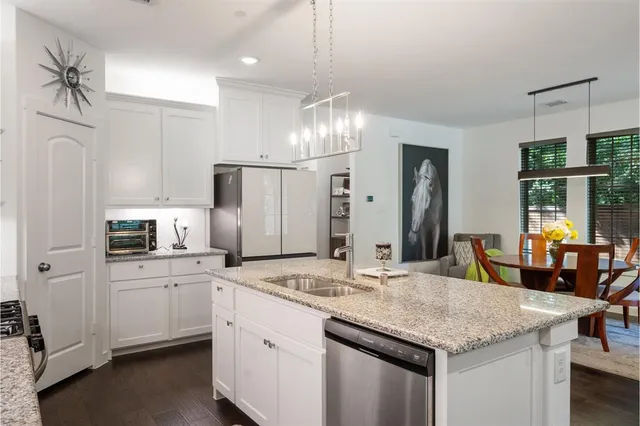 a kitchen with stainless steel appliances kitchen island granite countertop a sink and cabinets